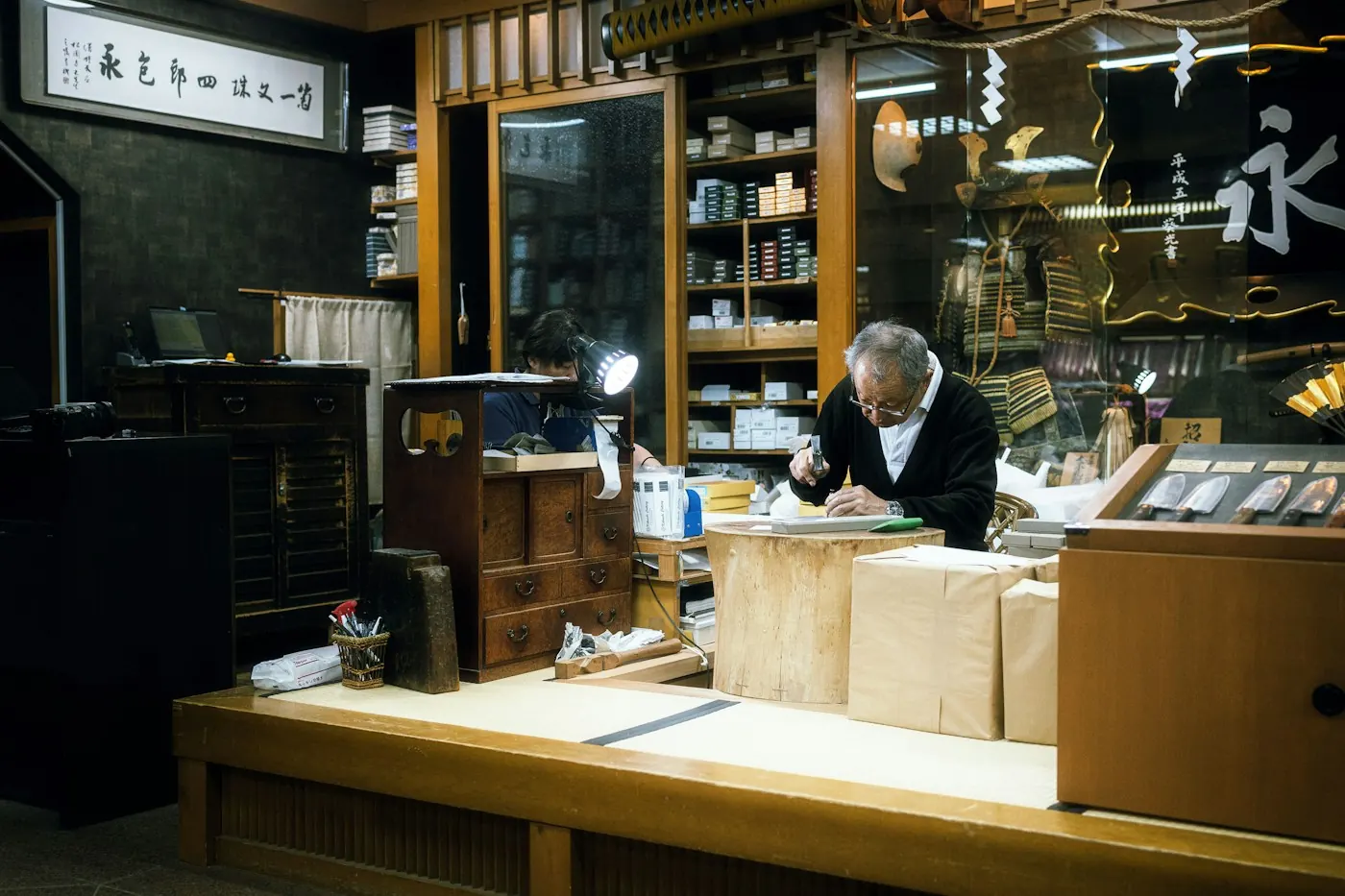 店のカウンターで作業する店主(イメージ)
