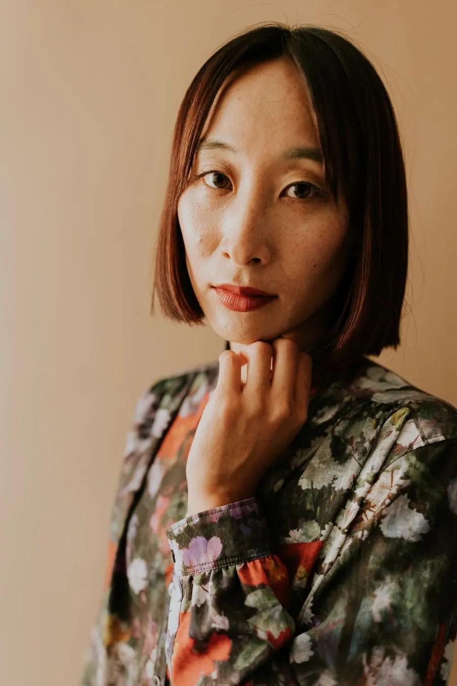 あご下のボブの女性が、ほほに手を添えている