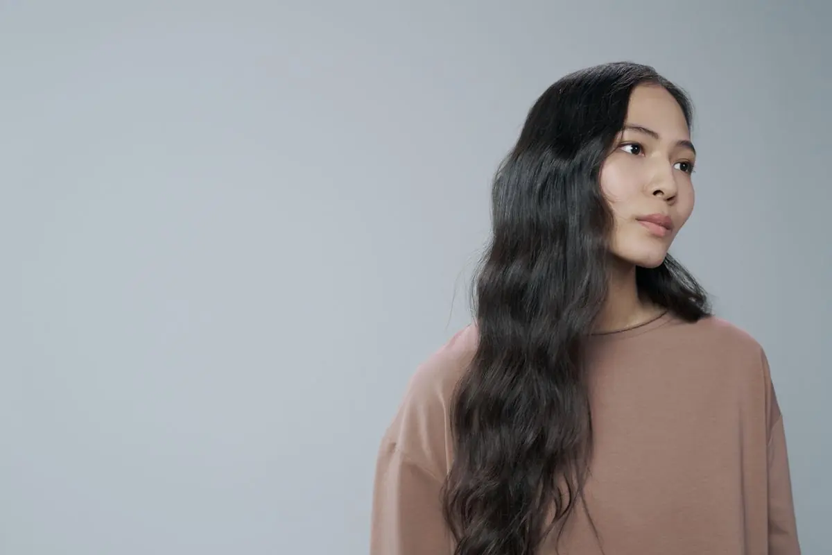 胸下まであるゆるいウェーブヘアの女性