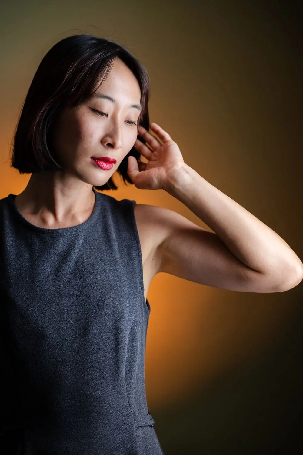 あご下のボブの女性が、髪を耳にかけている