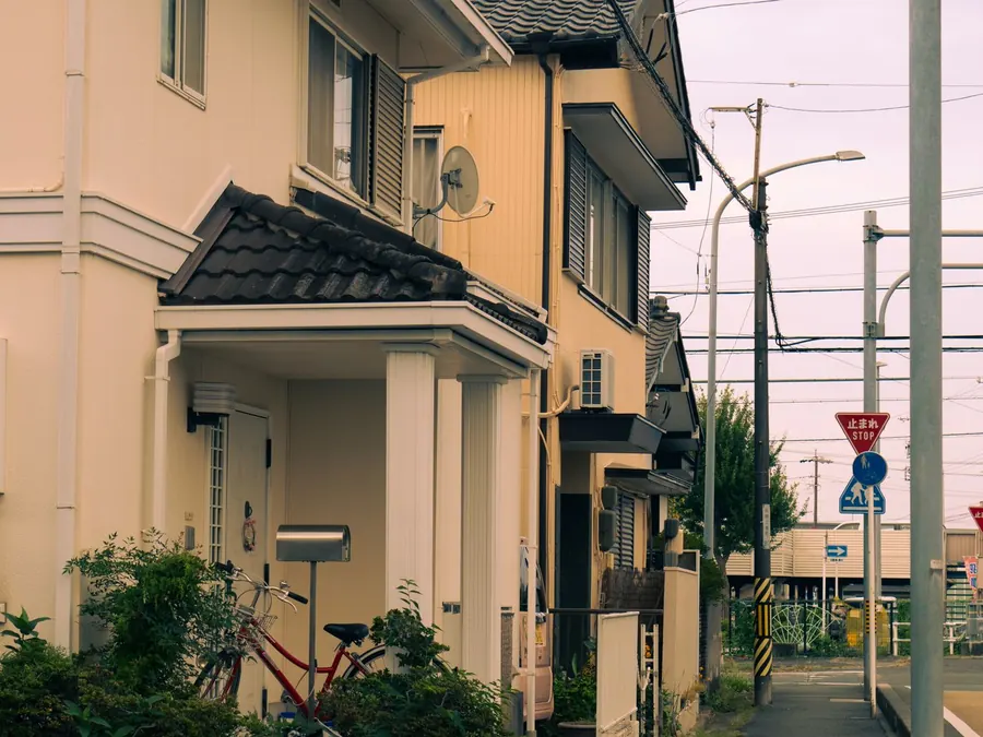 自転車が置かれた、通りに面した二階建て住宅