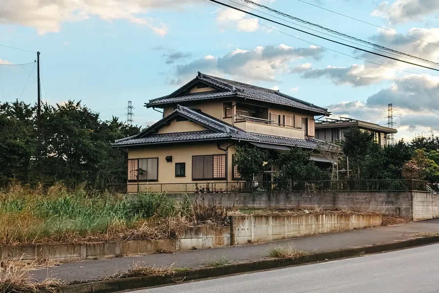 青空の下の、瓦屋根の二階建て住宅