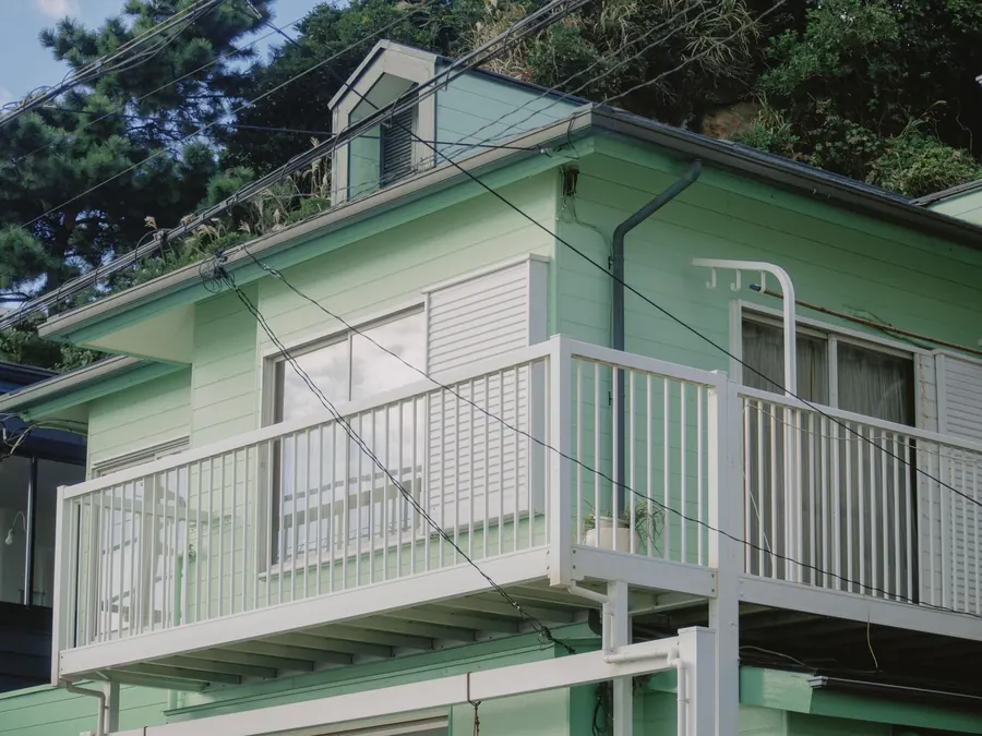 バルコニーのある、うすい緑色の家
