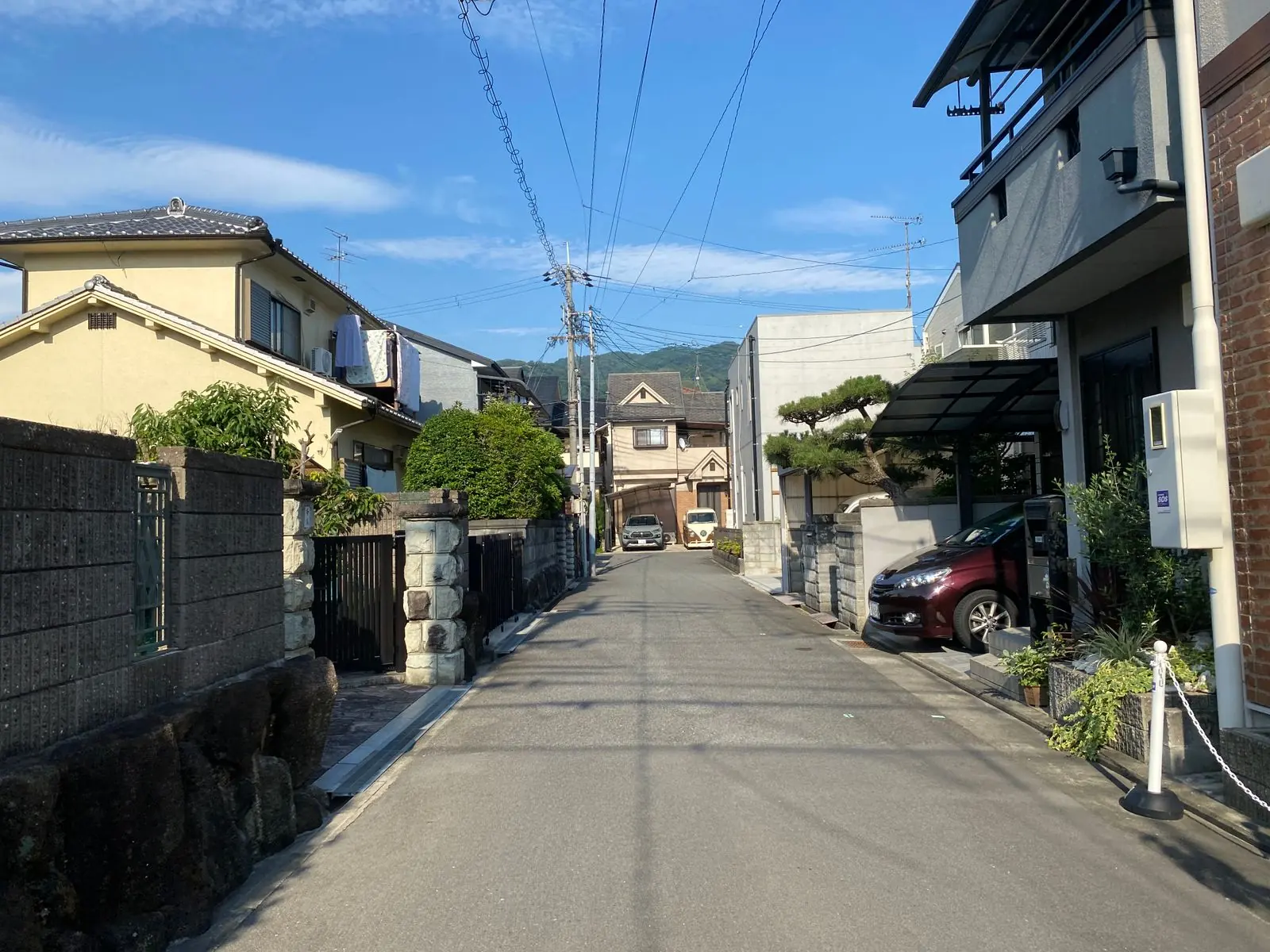 青空の下、住宅が並ぶ静かな通り