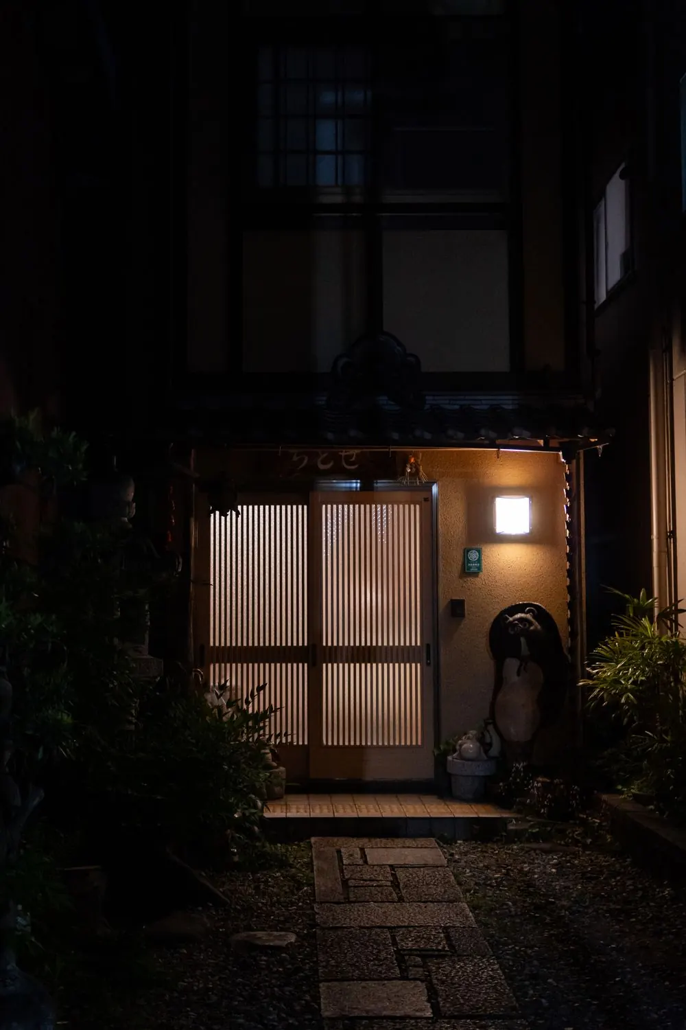 夜の玄関に灯りがともる住まい