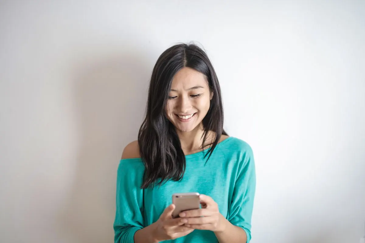 スマートフォンを見ながらほほえむ女性