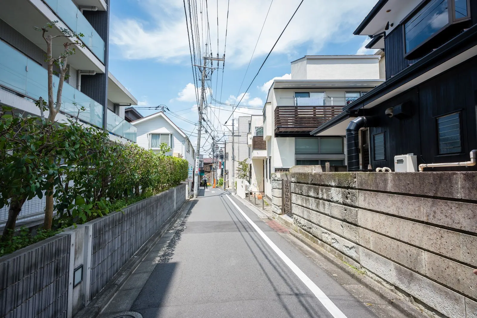青空の下の静かな住宅街の道