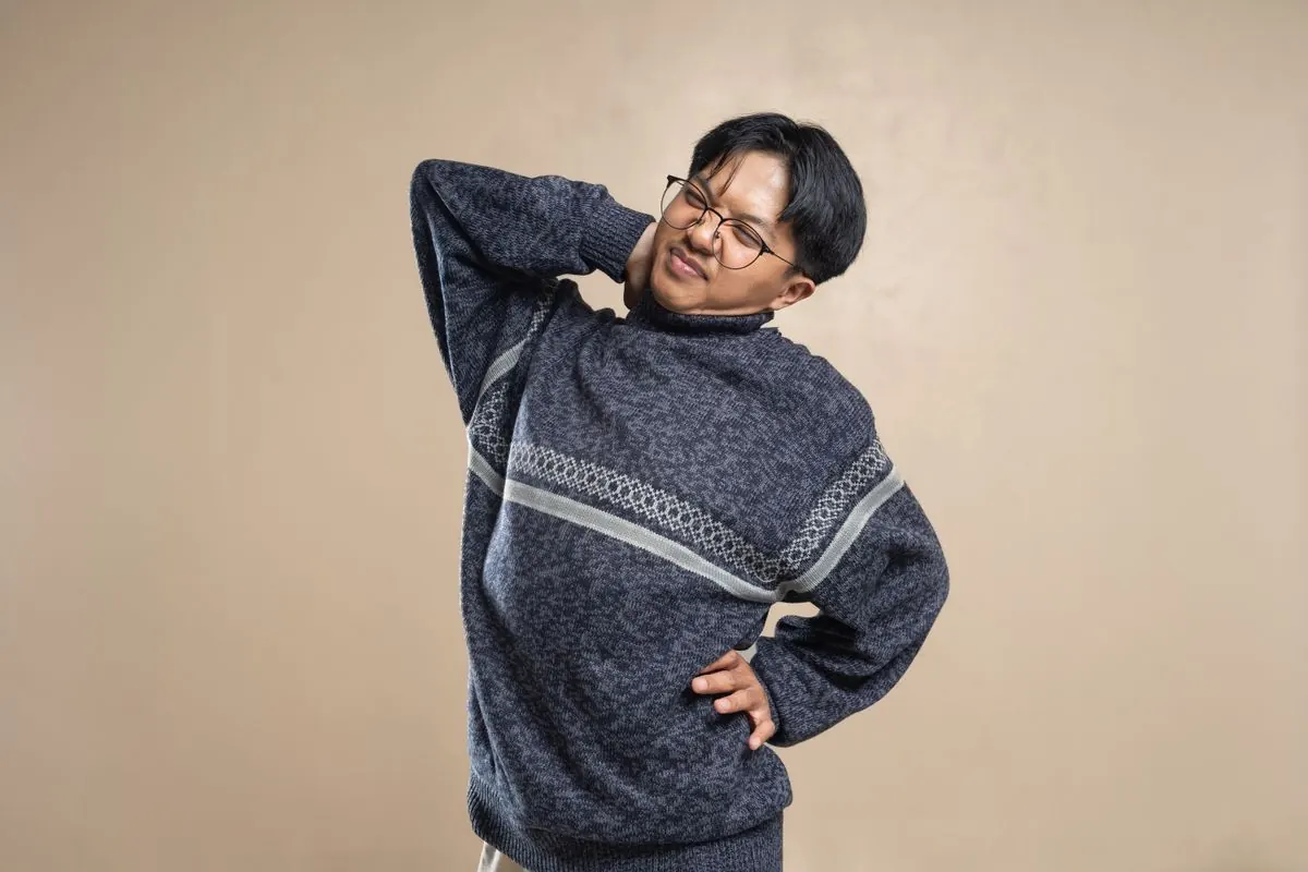 背中と腰に手を当てる男性