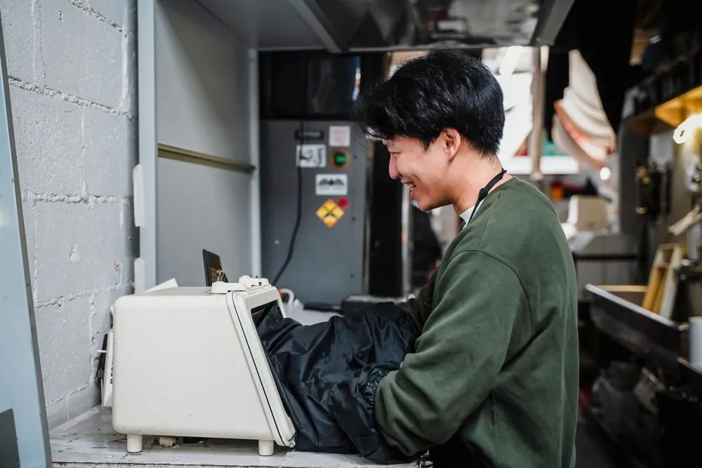 機械を操作しながら笑顔を見せる若手社員