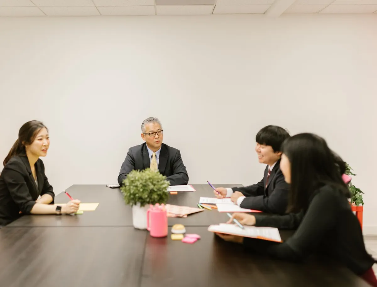 会議室のテーブルを囲んで話し合う会社のメンバー