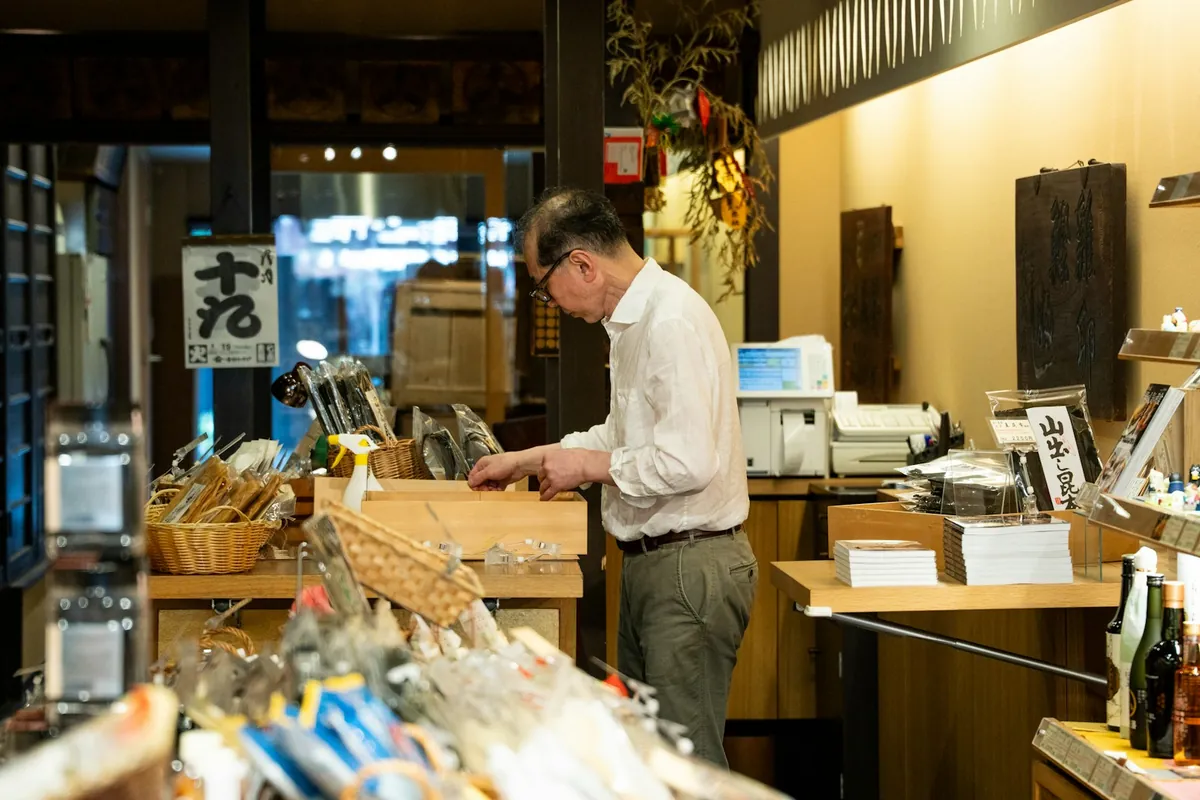商店のカウンターで商品を整える店主